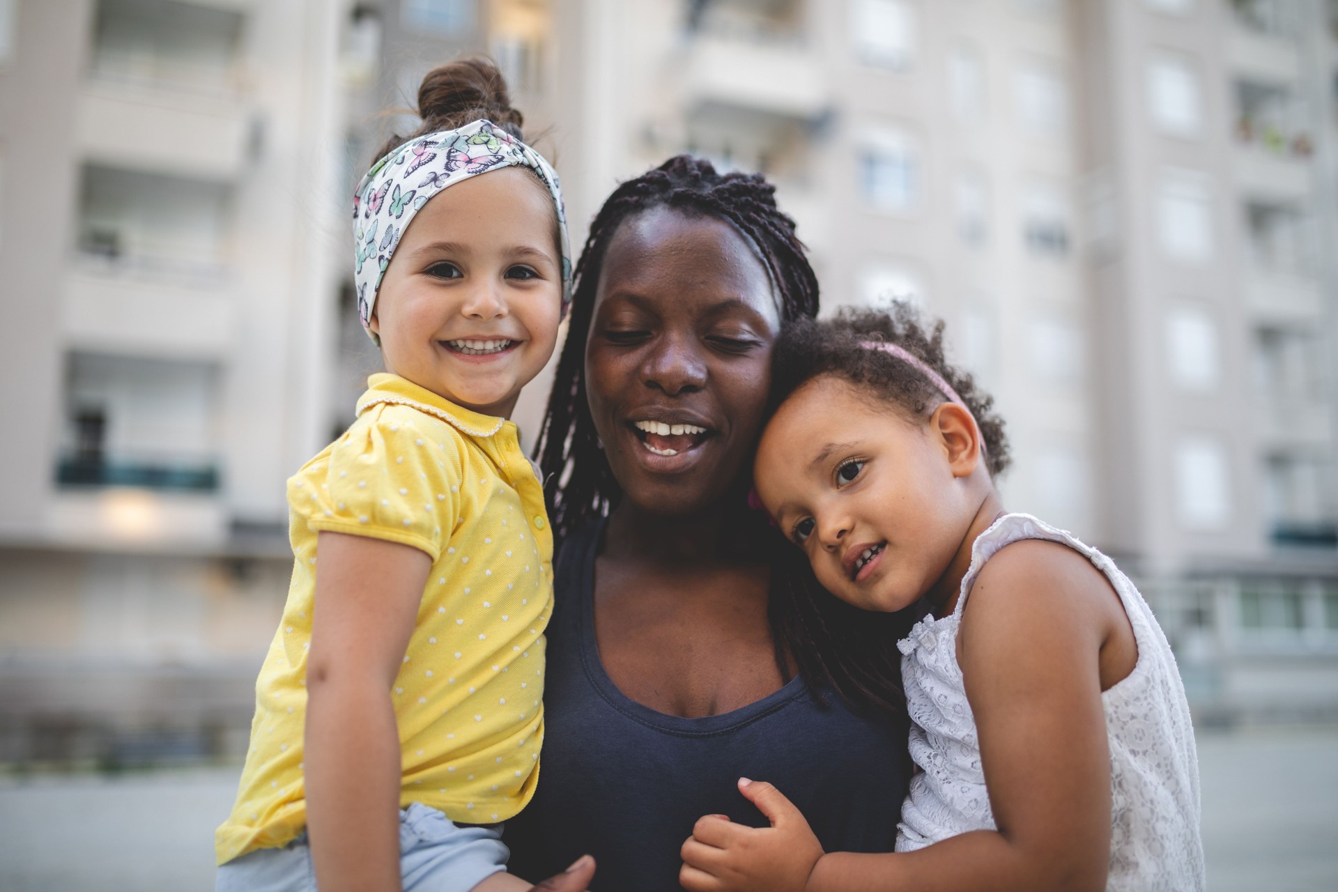 Smiling mixed race siblings and their lovely black mother