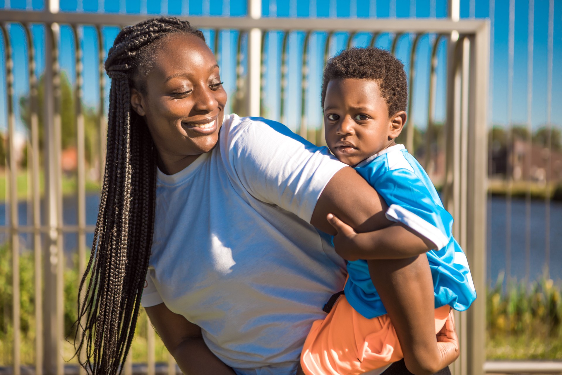 Black mother and young son training on the football pitch